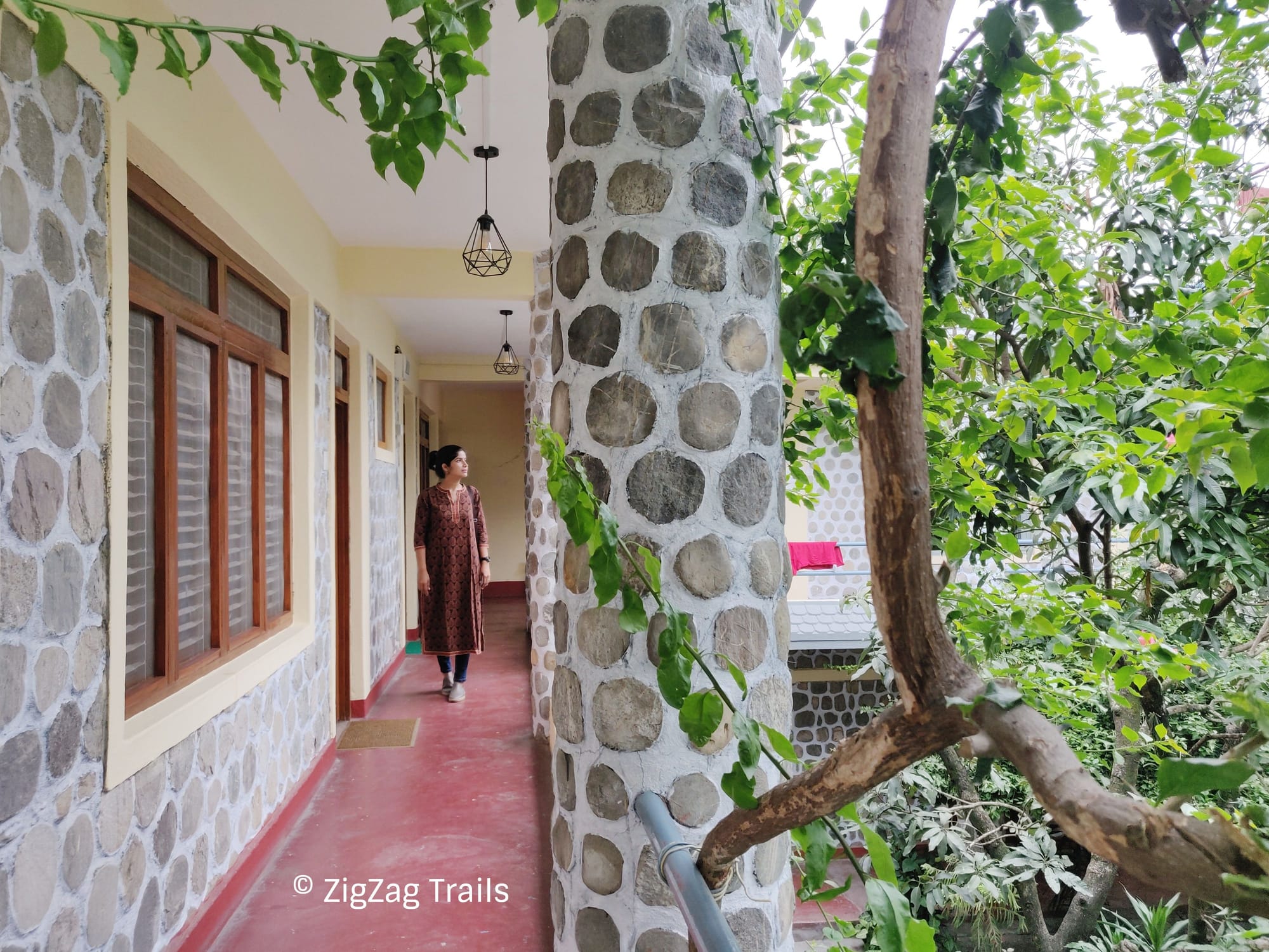 The corridor at first floor of Gaurishankar Backpackers Hostel with a huge green area in center.