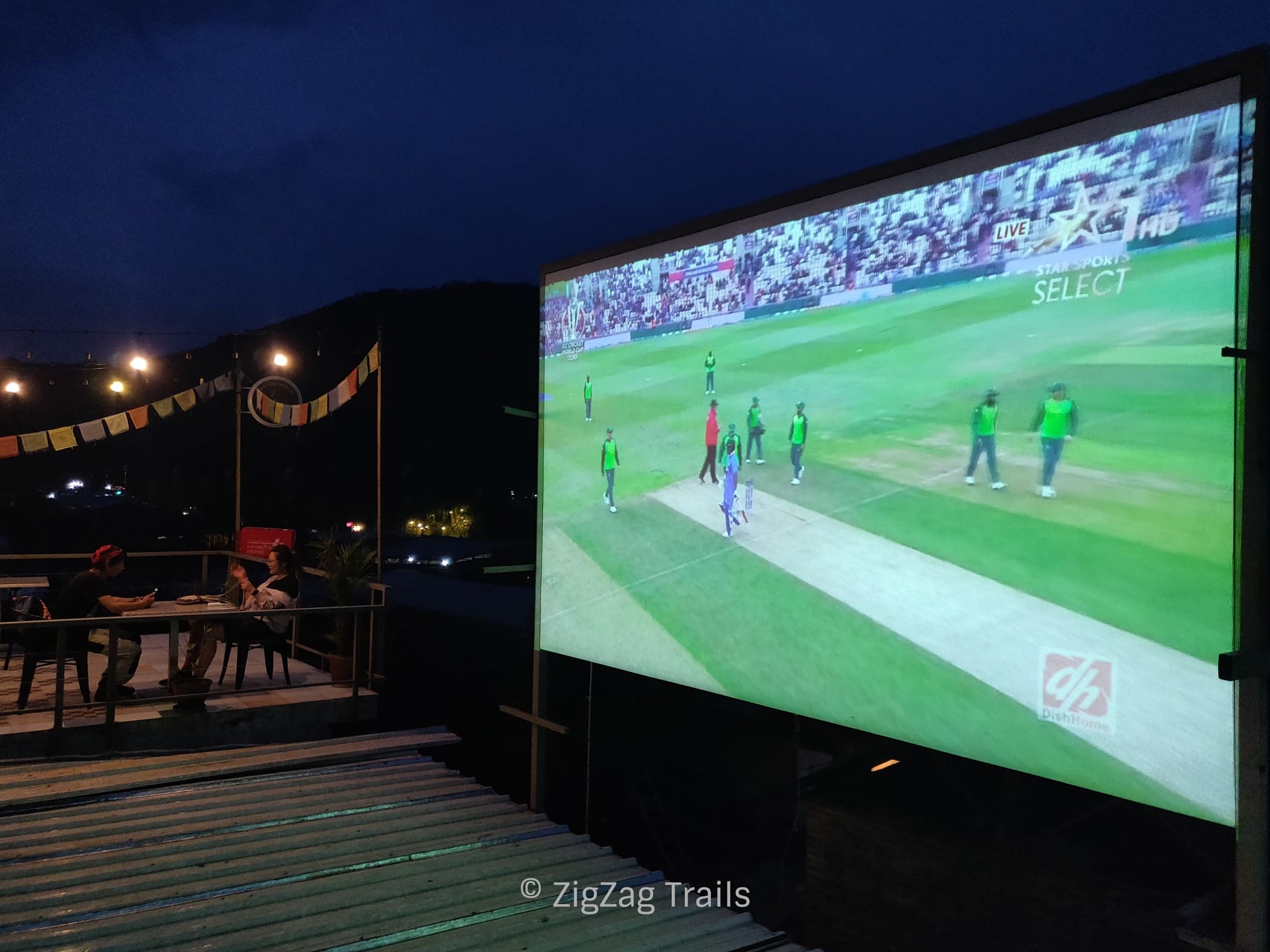 Watching cricket match on the life size screen at rooftop of Hostel Nepal Pokhara